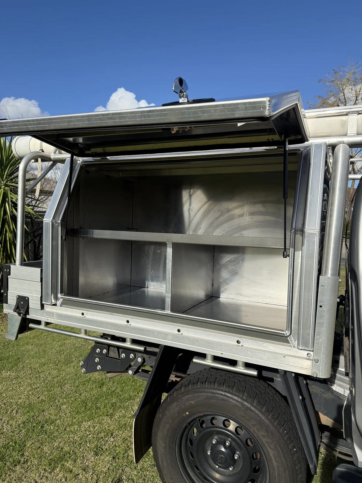 Open aluminium ute canopy showing shelving and storage compartments
