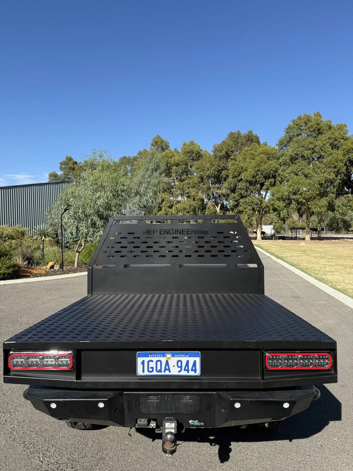 Black powder-coated aluminium ute tray with CNC cut-out headboard and LED tail lights